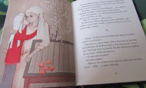 Wiłka smocza dziewczynka przytula mamę. Obok na stole leżą pomarańczowe kostki.
