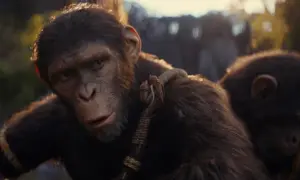 Wojownik z królestwa planety małp, z szarością na pysku, patrzy w dal. Obok niego młoda małpa.