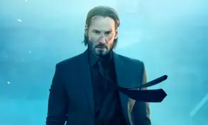 John Wick, z bliznami na twarzy, w garniturze, czeka na premierę John Wick 5.