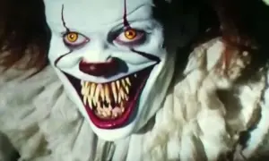 Przerażający horror z klaunem. Biała twarz, żółte oczy i ostre zęby.