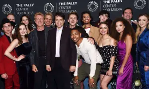 Uśmiechnięta cobra kai obsada pozuje do zdjęcia na tle logo The Paley Center for Media.