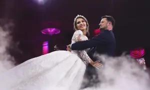 Para młoda tańczy w dymie. Ona w sukni ślubnej, on w garniturze. Idealny moment na rockowe piosenki na wesele.