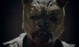 Przerażający Puchatek z filmu "Puchatek: Krew i miód 2", z krwawiącą paszczą i groźnym spojrzeniem.