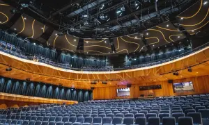 Nowe, nowoczesne sale koncertowe z wygodnymi, granatowymi fotelami i designerskim sufitem.