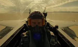 Pilot w hełmie "Maverick" w kokpicie myśliwca, gotowy do akcji. Scena jak z najlepszych filmów o lotnictwie.