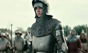 Młody rycerz w zbroi, gotowy do bitwy. Scena z filmów o średniowieczu, gdzie historia ożywa na ekranie.