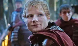 Ed Sheeran w stroju rycerza, jakby z planu "Gra o Tron", z towarzyszami w tle.