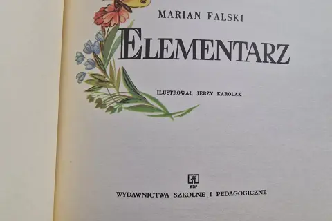 Ilustrowany elementarz z lat 60. Mariana Falskiego, z motywem motyla i kwiatów.