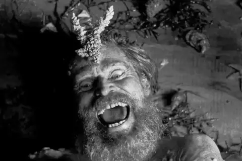 Szalony mężczyzna z porożem na głowie, krzyczący w mroku. Obraz idealny do najlepszych thrillerów psychologicznych.
