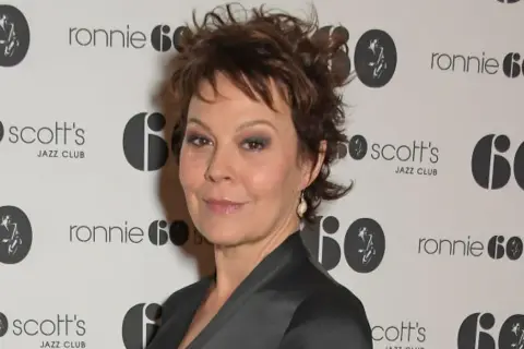 Helen McCrory, znana z filmów, seriali i programów, na tle logo Ronnie Scott's Jazz Club.