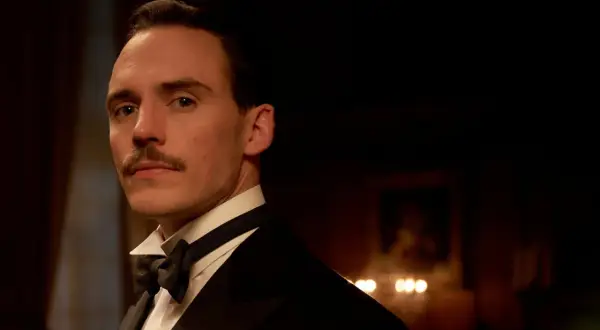 Oswald Mosley, z charakterystycznym wąsem, w eleganckim smokingu. Jego spojrzenie jest przenikliwe, zapowiadając intrygi z Peaky Blinders sezon 5.