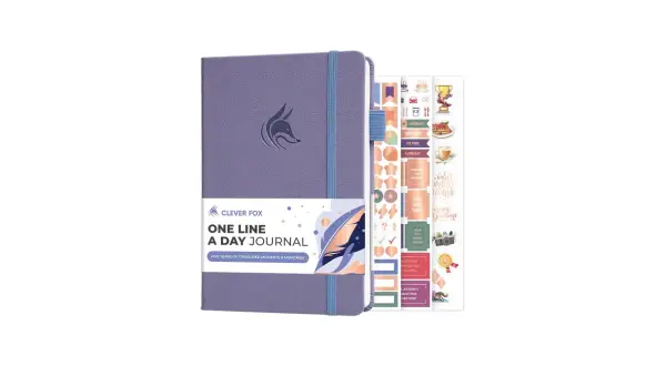 Fioletowy dziennik "One Line A Day Journal" z logo sprytnej kuny i zestawem motywacyjnych naklejek.