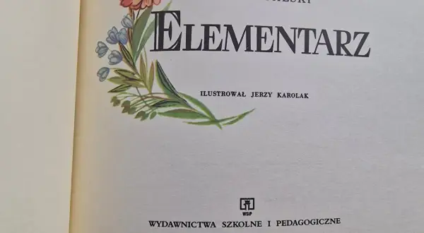 Ilustrowany elementarz z lat 60. Mariana Falskiego, z motywem motyla i kwiatów.