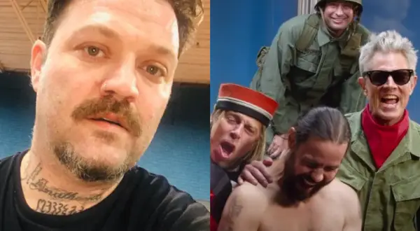 Bam Margera z tatuażami na szyi obok rozbawionej ekipy z Jackass 4.5 w wojskowych strojach.