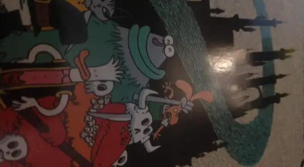 Kolorowy komiks z postaciami w stylu fantasy, przypominającymi bohaterów gry o nazwie "dożon". W tle widać zarys zamku.