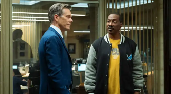 Kevin Bacon i Eddie Murphy, gwiazdy "Gliniarza z Beverly Hills", w rozmowie w biurze.