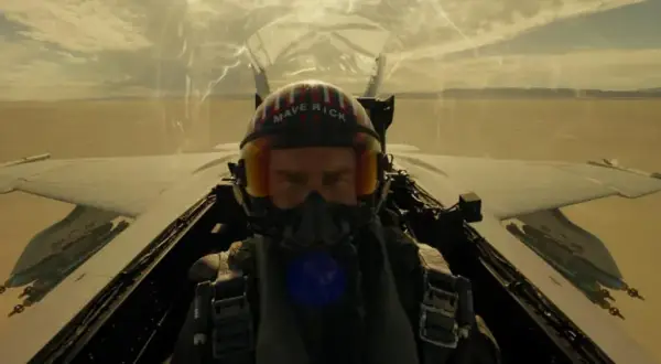 Pilot w hełmie "Maverick" w kokpicie myśliwca, gotowy do akcji. Scena jak z najlepszych filmów o lotnictwie.