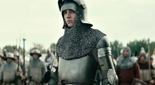 Młody rycerz w zbroi, gotowy do bitwy. Scena z filmów o średniowieczu, gdzie historia ożywa na ekranie.