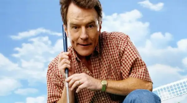Bryan Cranston w kratę, z kijem golfowym, przypomina postać z jego filmów i seriali.