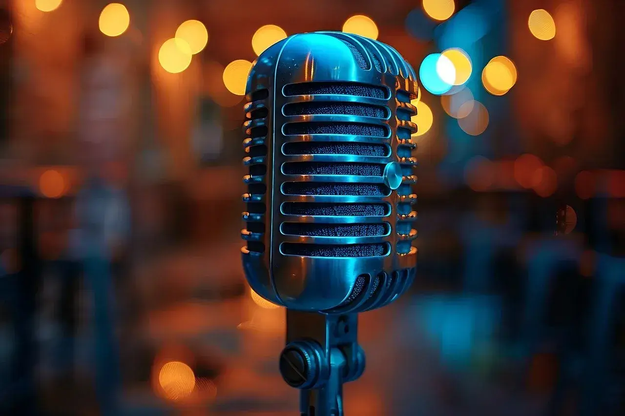 Klasyczny mikrofon gotowy do uchwycenia dźwięków muzyki jazzowej. W tle migoczą ciepłe światła.