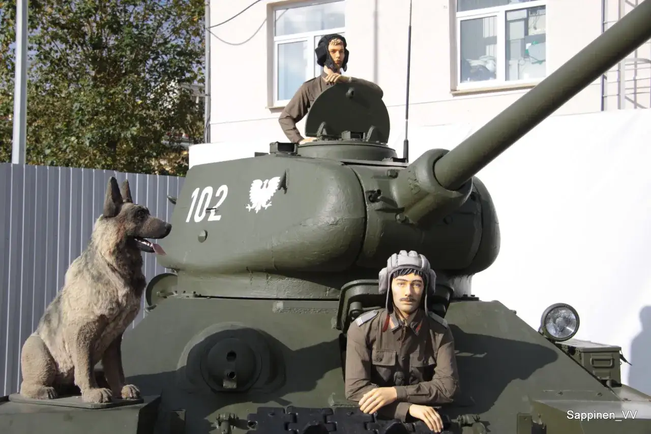 Janek z Czterech Pancernych i pies Szarik siedzą na czołgu.