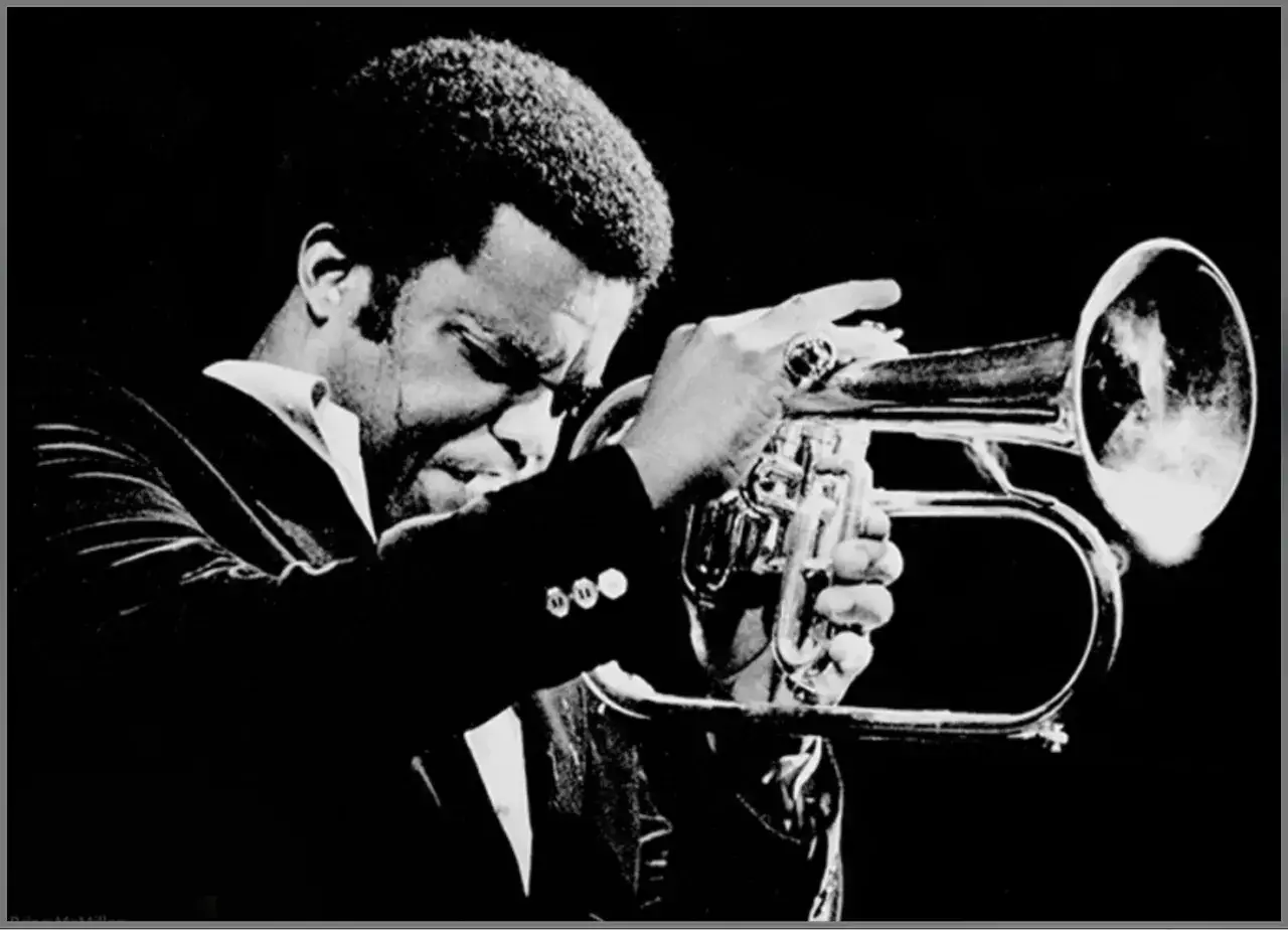 Wybitny muzyk jazzowy, Freddie Hubbard, grający na kornecie. Jego pasja do muzyki jazzowej jest widoczna w każdym geście.