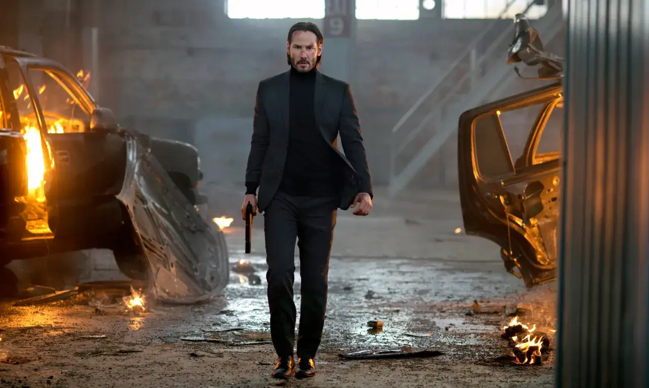 John Wick idzie przez płonące wraki samochod&oacute;w, gotowy na premierę John Wick 5.