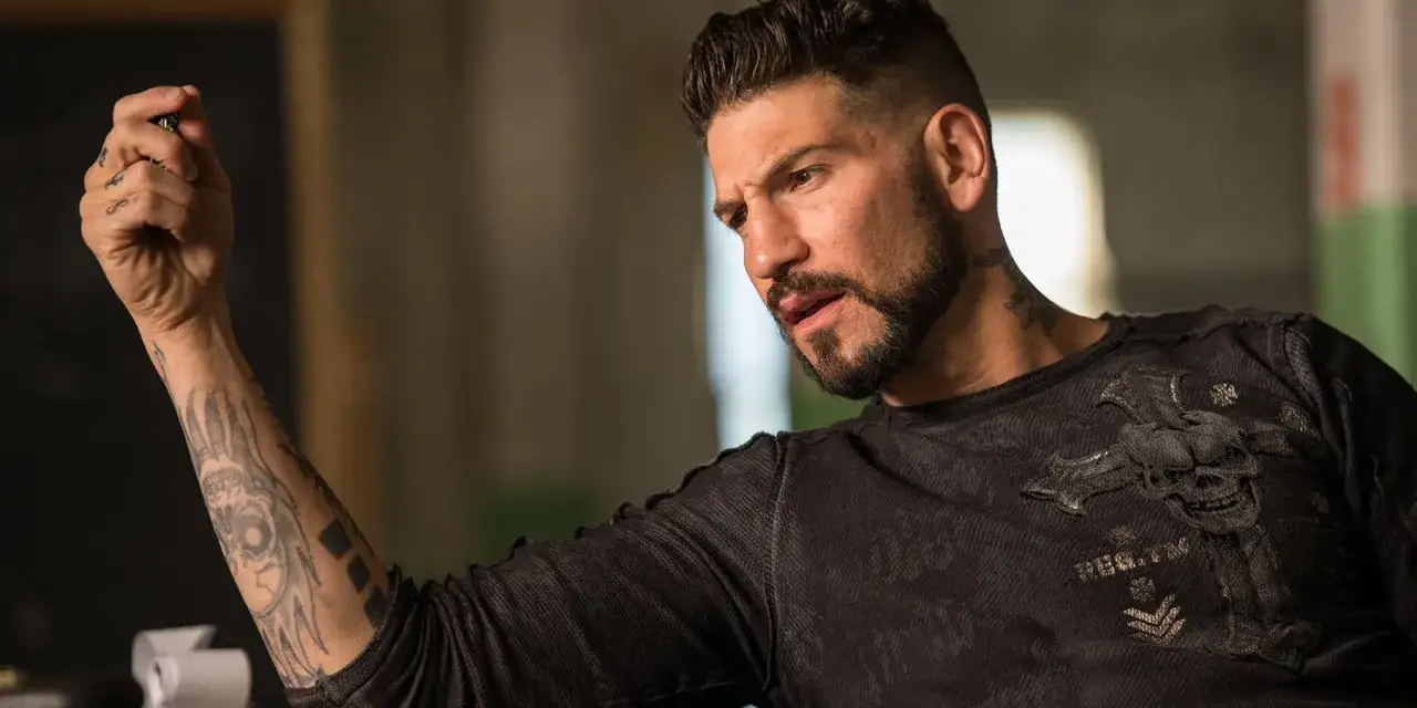 Jon Bernthal z tatuażami na ramieniu i szyi, w koszulce z czaszką, jak z jego filmów i seriali.