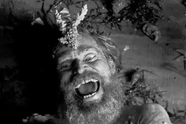 Szalony mężczyzna z porożem na głowie, krzyczący w mroku. Obraz idealny do najlepszych thrillerów psychologicznych.
