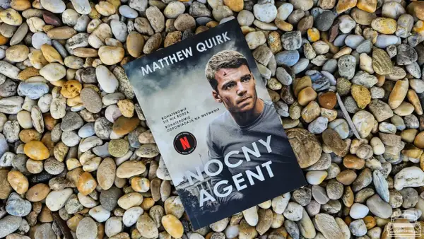 Okładka książki "Nocny agent" Matthew Quirka leży na kamieniach. Bohaterowie się nie rodzą, odpowiadają na wezwanie.
