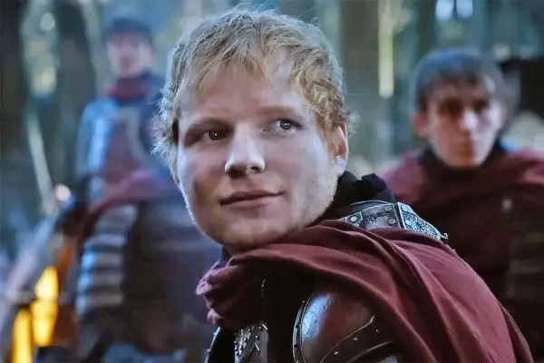 Ed Sheeran w stroju rycerza, jakby z planu "Gra o Tron", z towarzyszami w tle.